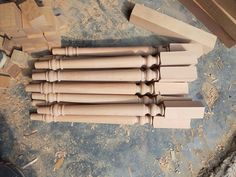 several unfinished wooden dowks are stacked on top of each other and ready to be assembled