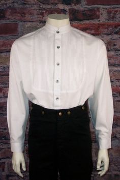 Men's Old West Vicorian Shirt This is one of our most authentic Victorian-era men’s shirts. This men’s shirt features a pleated inset bib and had a full button placket. The shirt sports a tailed banded collar of the Victorian/Edwardian era. Pewter buttons complete the authentic detail to this vintage style men’s shirt.The shirt is 100% cotton. Please machine wash in cold and tumble dry on low. Classic Cotton Shirt With Stand Collar, Classic Stand Collar Tops With Buttons, Classic Shirt With Stand Collar And Buttons, Classic Stand Collar Shirt For Fall, Classic Fall Shirt With Stand Collar, Fitted Classic Pleated Tops, Classic Collared Pleated Top, Classic Pleated Shirt For Formal Occasions, Formal Cotton Top With Stand Collar