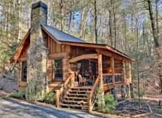 a log cabin in the woods with stairs leading up to it's front door