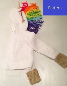 a white knitted sweater with a rainbow pony on it