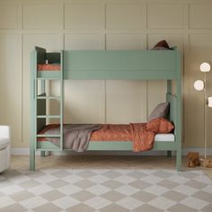 a bedroom with a bunk bed, chair and rug in the floor next to it