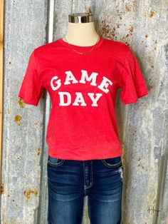 Show your team spirit under the Friday night lights with this red Game Day tee. + Fits true to size for unisex sizing + Red t-shirt + Game Day printed in white on front + Material- 52% Cotton 48% Polyester Sporty Red T-shirt With Letter Print, University Red Short Sleeve T-shirt For Game Day, Game Day T-shirt With Screen Print For Sports Season, Red Crew Neck T-shirt For Sports Season, Red T-shirt For Football Season Fan Merchandise, Red Fan Apparel T-shirt For Sports Events, Red Screen Print T-shirt For Sports Season, Red T-shirt For Football Season, Red Pre-shrunk T-shirt For Sports Season