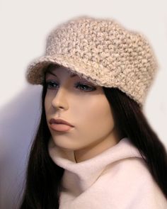 a mannequin head wearing a white sweater and a beige crocheted hat