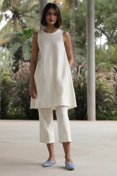 An elegant co-ord set in Lush Handwoven Chanderi silk. Sleeveless tunic with a close round neck. Back button fastening. In-seam pockets. Fully lined. Can be worn separately as a dress. Paired with easy, crop pants. Elasticated waist. In-seam pockets. Fully lined. Tip: Wear them together or mix and match with other styles in your wardrobe. Garment Measurements in inches: TUNIC XS S M L XL CHEST 34 35.5 37 38.5 40 WAIST 41 42.5 44 45.5 47 HIP 49 50.5 52 53.5 55 LENGTH 37 37.25 37.5 37.75 38 SHOULD Co Ords Outfits, Coord Sets, Casual Indian Fashion, Coord Set, Pakistani Dress, Stylish Dress Designs, Sleeveless Tunic, Shirts Design, Suit Designs