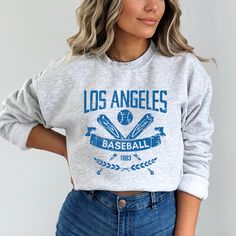 "This Los Angeles Baseball Apparel is the perfect way to cheer on the home team this season. Ideal for game day, tailgates or everyday wear. Makes a great gift for any fan. SHIRT DETAILS Bella Canvas Unisex - Solid colors: 100% Cotton. - Heather colors: 52% Cotton + 48% Polyester - Runs true to size. (For looser or oversized fit consider going up a size or 2. See photos for size chart.) SWEATSHIRT & HOODIE DETAILS Gildan Heavy Blend Unisex - 50% Cotton + 50 Polyester - Runs true to size. (For looser or oversized fit consider going up a size or 2. See photos for size chart.) CARE INSTRUCTIONS Do not dryclean; Machine wash: cold (max 30C or 90F); Non-chlorine: bleach as needed; Tumble dry: low heat; Iron or steam: medium heat. Wash, dry and iron inside out. MORE DESIGNS AVAILABLE https://www Gear Outfit, Baseball Apparel, Hoodie Details, Baseball Outfit, Womens Apparel, Baseball T Shirt, Sports Fan, San Jose Ca, Sweatshirt Hoodie