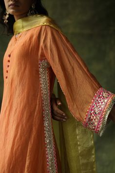 Editor's Note A Contrast Kurta Set In Chanderi Silk With Gota Embroideries On The Sides, Sleeves And The Ghera. The Pants Are A Contrast Pop With Hand Embroidered Floral Bootis. The Dupatta With Hand Made Tassels Add A Further Festive Pop To The Outfit. Color: Burnt Orange Fabric: Chanderi Silk Kurta, Modal Satin Lowers, Satin Slip Organza Dupatta Care: Dry Clean Only Disclaimer: The actual colour of the outfit may differ slightly than the image shown owing to different monitors and photography Pakistani Fashion Party Wear, Salwar Kamiz, Traditional Indian Outfits, Kurti Neck Designs, Kurta Designs Women, Designer Dresses Casual, Boutique Dress Designs, Stylish Dress Book, Pakistani Dress Design