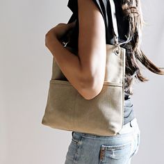 a woman carrying a beige tote bag on her shoulder