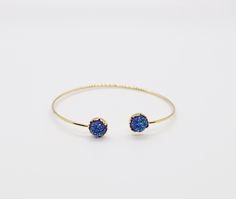 The Druzy Navy Blue Stone End Cuff Bracelet is a lightweight bracelet that is great to use for stacking with other bracelets. It is a beautiful bracelet that will add a touch of elegance to any outfit. Elegant Blue Wrap Bracelet As Gift, Elegant Blue Wrap Bracelet As A Gift, Elegant Blue Stackable Crystal Bracelet, Elegant Adjustable Blue Cuff Bracelet, Blue Stackable Wrap Bracelet As Gift, Adjustable Stackable Bangle Bracelets, Elegant Blue Cuff Bracelet For Gift, Adjustable Blue Stackable Wrap Bracelet, Blue Bangle Crystal Bracelet As Gift