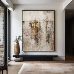 an abstract painting hangs on the wall next to a large vase