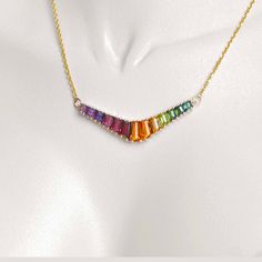 Discover our 18K Gold Rainbow V-Shaped Pendant Necklace, a striking fusion of vibrant hues and contemporary design that embodies diversity and self-expression. This pendant showcases a sleek V shape adorned with meticulously arranged multicolored gemstones, forming a captivating spectrum symbolizing unity within differences. Multicolor Fusion Necklaces With 17 Jewels, Luxury Multicolor Necklace With Gemstone Accents, Luxury Multicolor Necklaces With Gemstone Accents, Luxury Multicolor Gemstone Necklaces, Luxury Multicolor Multi-stone Necklaces, Luxury Multicolor Necklaces With Natural Stones, Luxury Multicolor Natural Stone Necklaces, Luxury Multicolor Natural Stone Necklace, Modern Multicolor Gemstone Jewelry