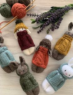 crocheted stuffed animals are sitting next to balls of yarn and flowers on a table