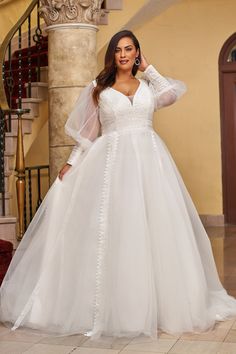 a woman in a white wedding dress posing for the camera