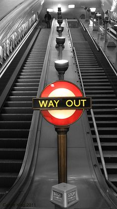 a sign that says way out on the side of an escalator in a subway