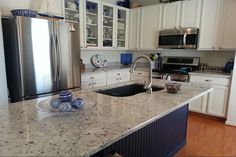 a kitchen with marble counter tops and stainless steel appliances