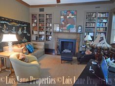 a living room filled with furniture and a fire place in the middle of a room