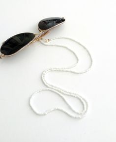 Beaded sunglasses chain, Eyewear holder, Sunglasses necklace, White beaded glasses holder, Sunglasses white strap, Eyeglasses beaded cord Beautiful fashion trend sunglasses beaded string This sunglass strap is lightweight, comfortable to wear and secures your sunglasses on your neck. Fashion trend accessory for the summer!  Total length is 70cm / 27.7 inches. Beautifully packaged and ready for gift giving.  JEWELRY CARE: Please take care of your jewelry do not wear in the shower, swimming pool, Beaded Sunglasses Chain, Bridesmaid Sandals, Sunglass Strap, Beaded Glasses, Beaded Sunglasses, Trend Sunglasses, Staple Shoes, Sunglasses Necklace, Eyewear Chain