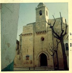 an old building with a clock on the front and side of it's tower