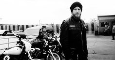 a man standing next to two parked motorcycles