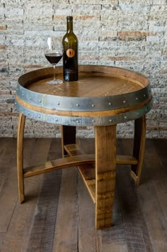 a wine barrel table with a bottle of wine on it and a glass in the middle