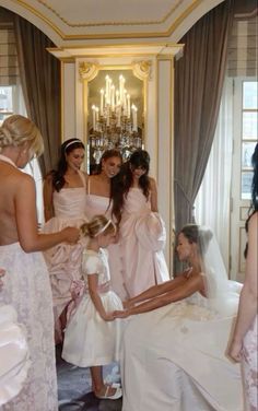 a group of women standing next to each other in front of a bride's dress