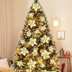 a decorated christmas tree in a living room with white and gold decorations on the top