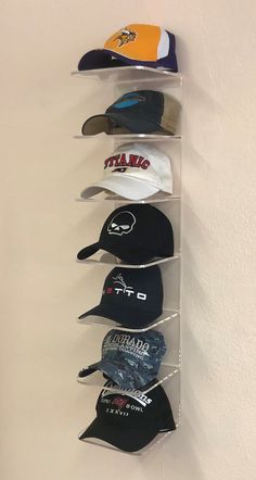 several hats are hanging on the wall in a hat rack with clear acrylic