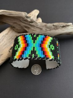 "Native America Indian Jewelry. This is a stunning fully beaded Navajo bracelet. Made by hand from a Navajo family of women that do spectacular beadwork in a wide variety of items. This beautiful bracelet is 1.50\"x 6\" end to end with a 1.25\" opening, white leather over playable metal. This is a gorgeous colorful bracelet that will look fabulous on everyone! Please look closely at photos. Welcome to NorthWestTradingCo" Black Bohemian Cuff Bracelet With Round Beads, Black Beaded Bohemian Cuff Bracelet, Southwestern Festival Cuff Bracelet With Round Beads, Southwestern Style Large Beads Bracelet For Festivals, Southwestern Black Beaded Bracelet With Colorful Beads, Southwestern Style Black Beaded Bracelet With Colorful Beads, Southwestern Style Multicolor Beaded Bracelets With Large Beads, Southwestern Style Multicolor Beaded Cuff Bracelet, Southwestern Multicolor Cuff Bracelet For Festival