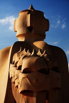 a large wooden statue is in front of a blue sky