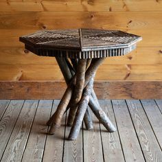 a table made out of sticks sitting on top of a wooden floor