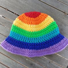 a multicolored crocheted hat sitting on top of a wooden table