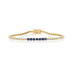 A true classic, our Diamond Four Prong Tennis Bracelet is accented with larger four prong set blue sapphires at the center. Handcrafted in 18-karat yellow gold and set with 1.50 carats of round, brilliant-cut white diamonds this bracelet has timeless appeal - the perfect gift for yourself or someone you love, because diamonds are always a good idea! Bracelet measures 6.5 inches in length Diamond Carat Weight: 1.50 ct Blue Sapphire Carat Weight: 0.53 ct Stone size: 1.5 mm / Accent - 2.5 mm Diamon Classic Yellow Gold Diamond Bracelet With Channel Set, Classic Yellow Gold Bracelet With Channel Set, Classic Yellow Gold Diamond Bracelet Channel Set, Classic Yellow Gold Channel Set Diamond Bracelet, Classic Yellow Gold Bracelet Channel Set, Classic Yellow Gold Bracelets Channel Set, Sapphire Tennis Bracelet Fine Jewelry With Prong Setting, Classic Sapphire-colored Cubic Zirconia Bracelets, Classic Sapphire Tennis Bracelet With Prong Setting