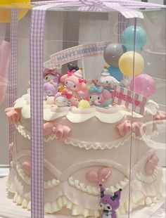 there is a large cake with lots of stuffed animals on it and balloons in the background