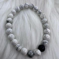 White Marble Beads With A Dark Stone Colored Bead Stretch Bracelet Handmade Everyday White Beaded Bracelets With Round Beads, Everyday White Stretch Bracelet With Large Beads, Everyday White Beaded Bracelets, Casual White Spacer Beads, Casual White Crystal Bracelet, White Beaded Minimalist Stretch Bracelet, Casual White Beaded Bracelets With Faceted Beads, Casual White 8mm Bead Jewelry, Casual White Jewelry With 8mm Beads