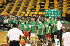 a group of young men standing next to each other on a basketball court