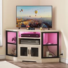 a flat screen tv sitting on top of a wooden entertainment center next to a window