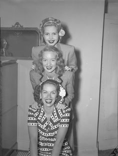 an old black and white photo of three women in front of a mannequin