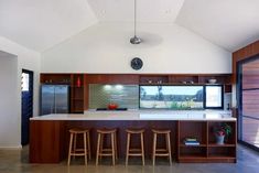 a kitchen with an island and bar stools in front of the counter top area