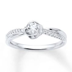 a white gold ring with diamonds on the band and a center stone in the middle