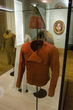 an old fashion clothing on display in a glass case