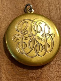 This lovely old locket is part of my antique locket collection which I am beginning to put up for sale.  It is a  round gold locket that was acid tested to be 9 or 10 k solid yellow gold.  It is beautifully hand engraved with elaborately entwined letters which I cannot make out. Perhapse you can!  It is also engraved with a date, "Nov 11th 1902". The  locket snaps shut tightly and opens with the aid of two little divits on the edge for your finger nails. Using a knife blade would scratch up and mar the gold.  The hinge is also tight and in perfect, vintage condition.  Judging from its construction, and the engraving, I'd say this locket was made about  1900,  making it about 125 yers old.  It  is simple and elegant, with it's round shape and mellow satin finish with absolutely no dents, ju Vintage 14k Gold Locket Necklace Stamped 14k, Vintage 14k Gold Locket Necklace, Victorian Round Locket Necklace Stamped 14k, Antique Medallion Locket Necklace Stamped 14k, Antique Engraved White Gold Locket Necklace, Victorian Jewelry With Engraving Option For Gifts, Victorian Engraved Locket Necklace For Memorials, Vintage Engraved White Gold Locket Necklace, Victorian Etched Locket Necklace For Memorial