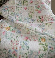 a quilted bed with flowers on it