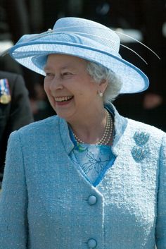 an older woman wearing a blue coat and hat