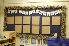 a bulletin board with brown paper on it and some blue bags in front of it