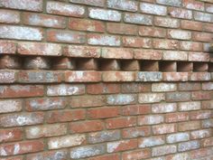 a brick wall with several holes in it