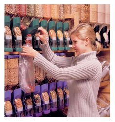 a woman is shopping in a grocery store and holding up a plastic bag full of food