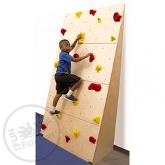 a young boy climbing up the side of a rock wall