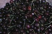 a pile of black cherries sitting on top of a table