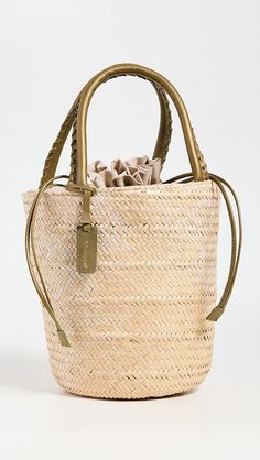 a straw bag with braid handles on a white background