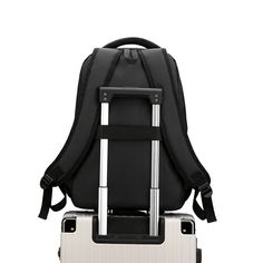 a black and white backpack sitting on top of a piece of luggage in front of a white background