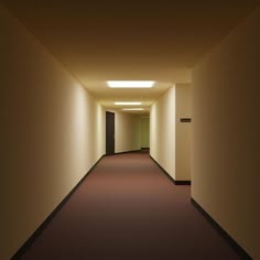 an empty hallway with lights on either side and dark carpeted flooring in the middle